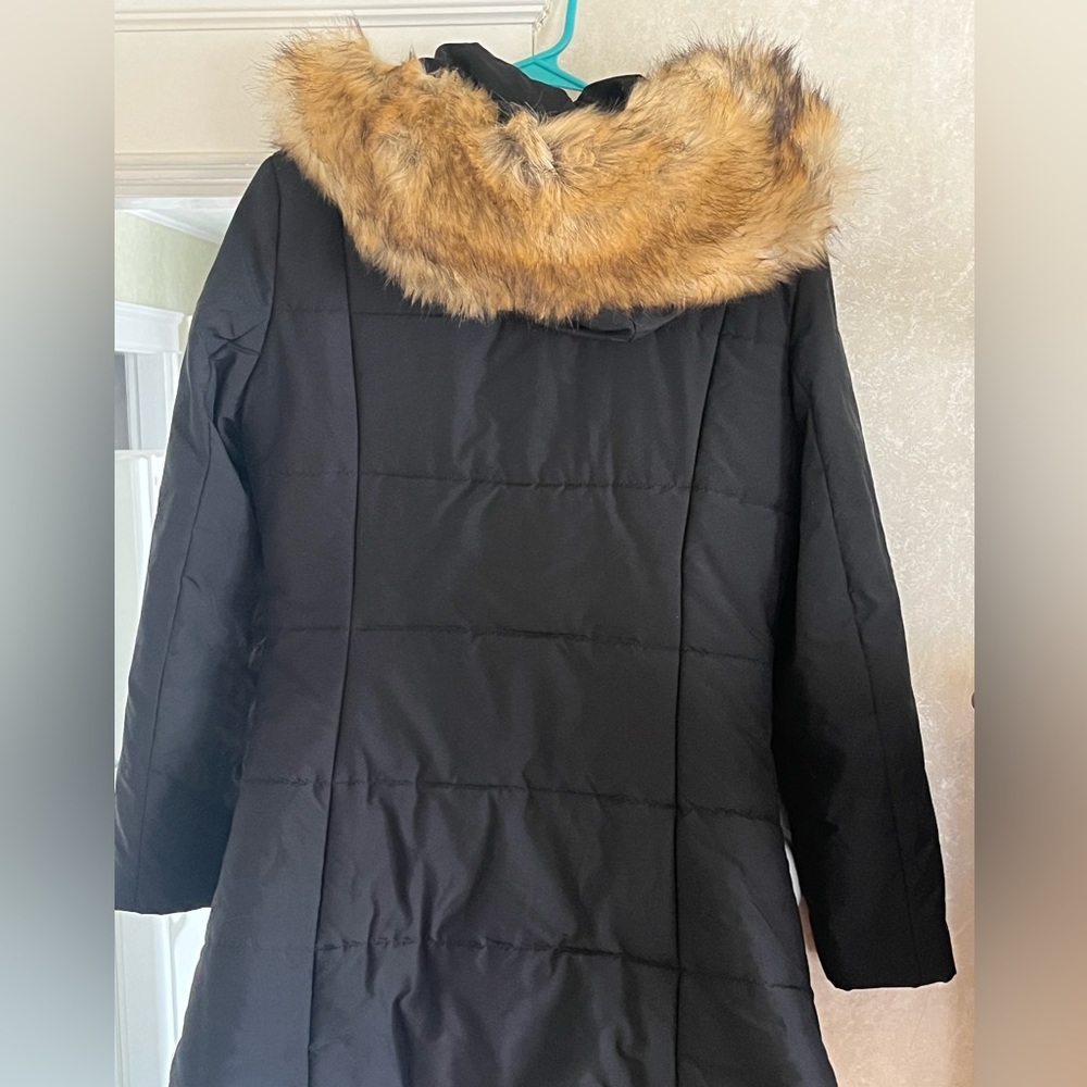 Black womens thigh length coat with hood on the fur. Not very heavy.